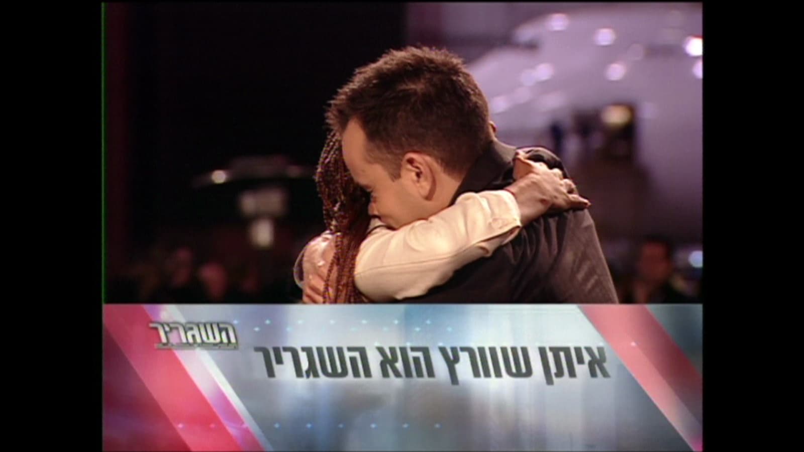 Eytan Schwartz embracing another contestant as an on-screen caption names him the winner.