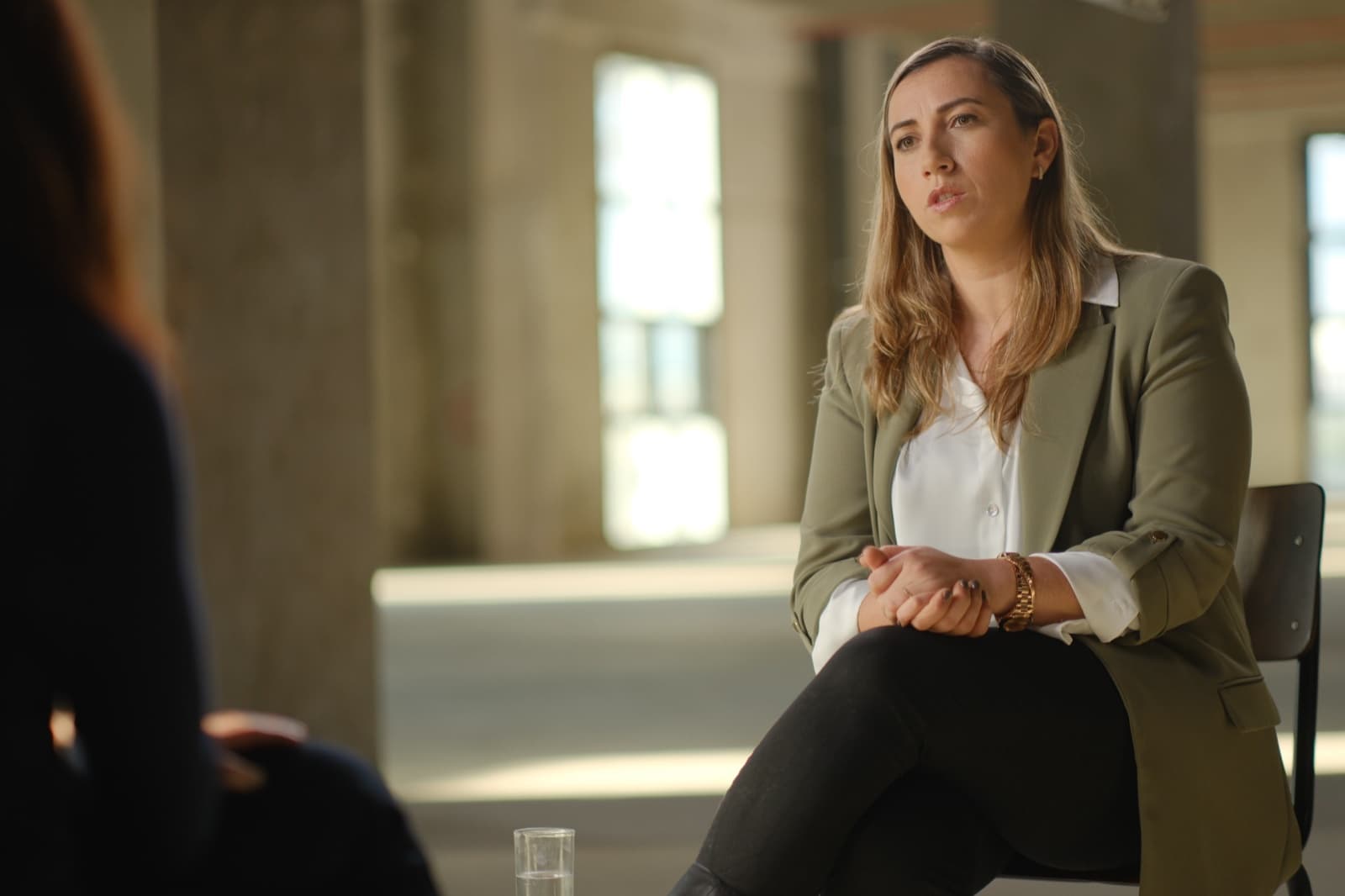 Dr. Cochav Elkayam-Levy during her interview for Screams Before Silence, seated in a bright industrial space.